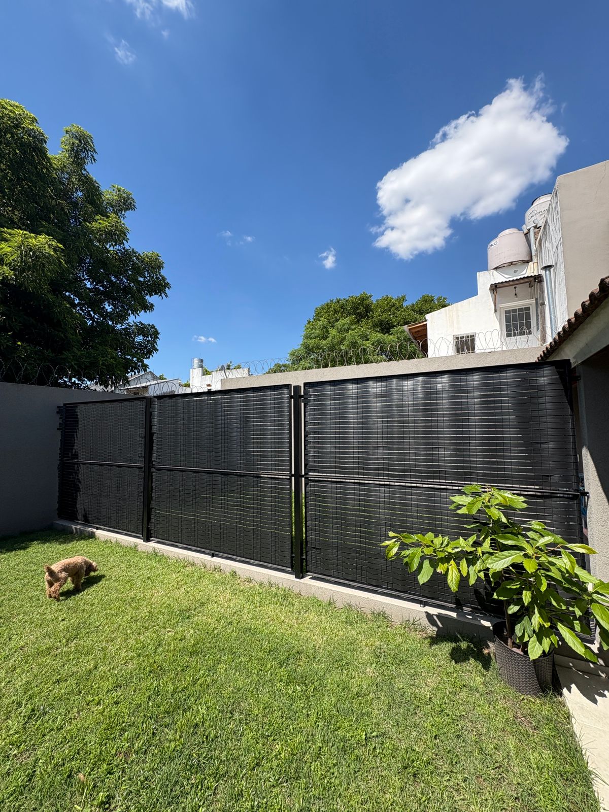 Instalación real de cinta cubre cerco en un jardín